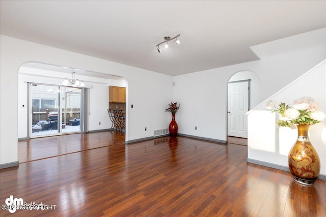 empty room featuring dark hardwood / wood-style flooring and a chandelier