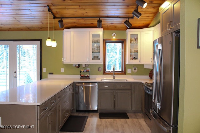 kitchen with white cabinetry, sink, decorative light fixtures, and stainless steel appliances