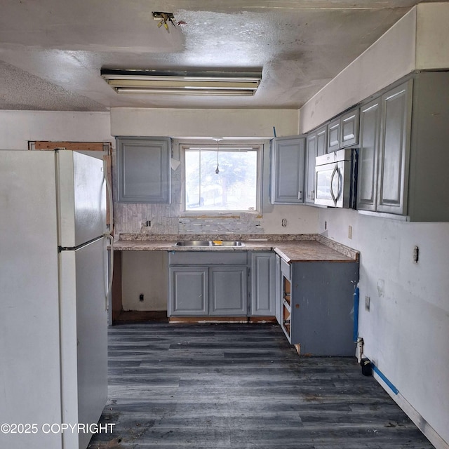 kitchen with gray cabinetry, dark hardwood / wood-style floors, and white fridge