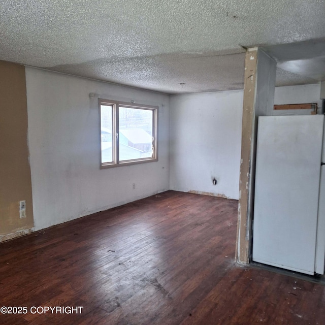 empty room featuring dark hardwood / wood-style flooring and a textured ceiling