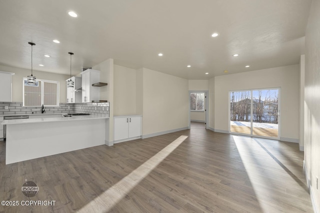 kitchen featuring white cabinetry, hanging light fixtures, tasteful backsplash, and light wood-type flooring