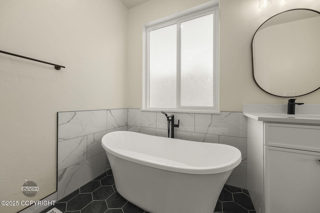 bathroom featuring vanity, a healthy amount of sunlight, tile walls, and a bathtub