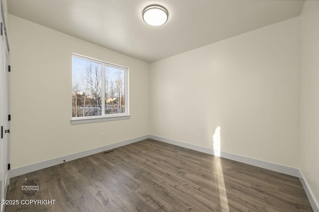 empty room with dark hardwood / wood-style flooring