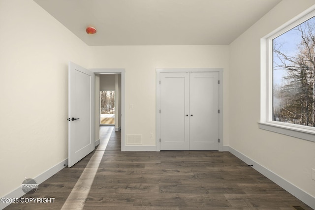 unfurnished bedroom featuring dark hardwood / wood-style flooring and a closet