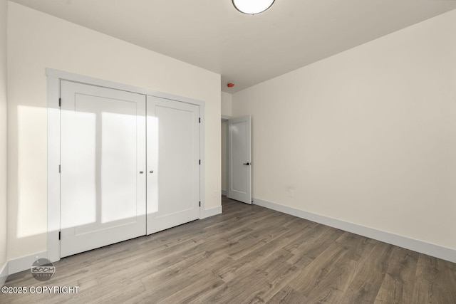 unfurnished bedroom featuring wood-type flooring and a closet