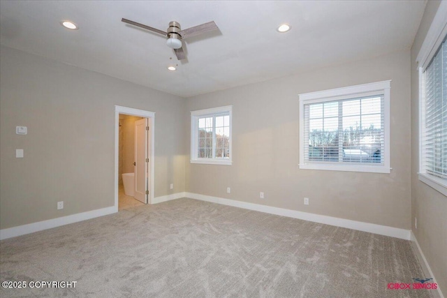 unfurnished bedroom with multiple windows, connected bathroom, and light colored carpet