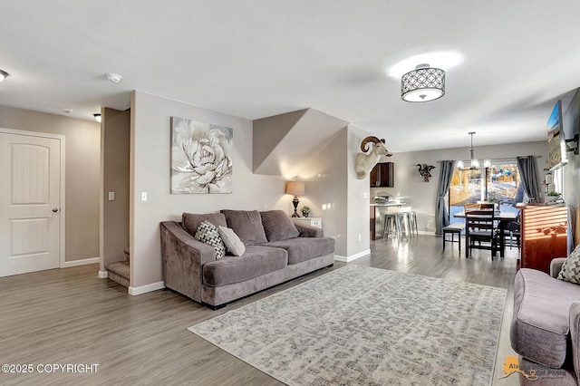 living room featuring a notable chandelier and light hardwood / wood-style floors