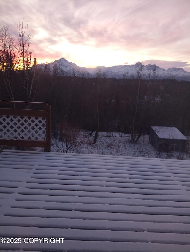 deck at dusk featuring a mountain view