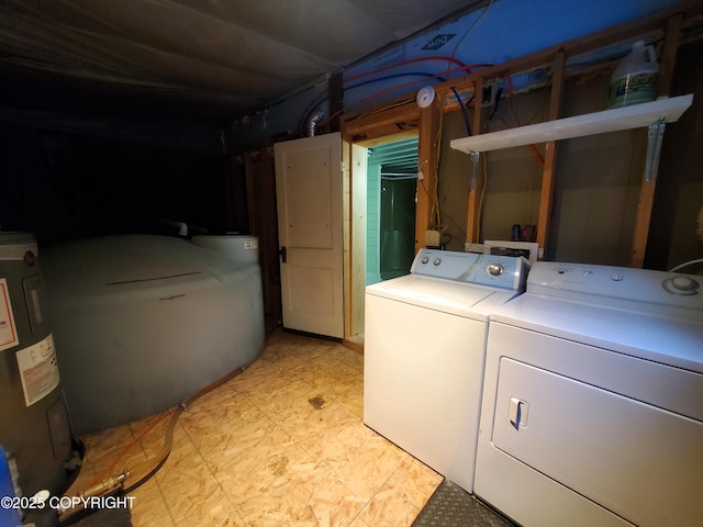 clothes washing area with water heater and washer and dryer