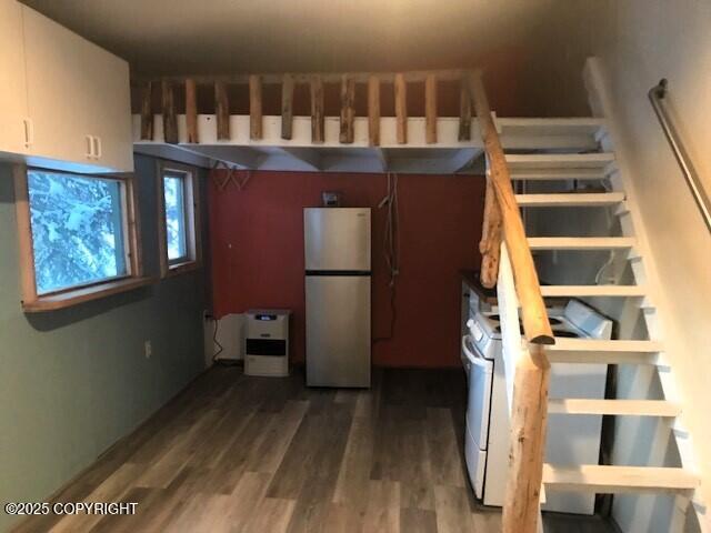 kitchen featuring hardwood / wood-style flooring, white cabinetry, fridge, and white range with gas stovetop