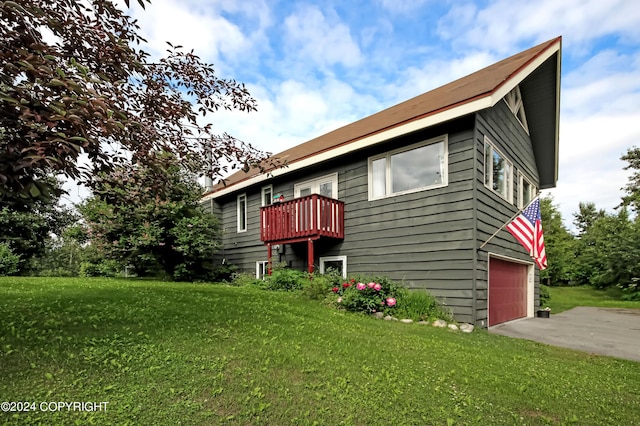 view of front of house with a front lawn, a garage, and a balcony