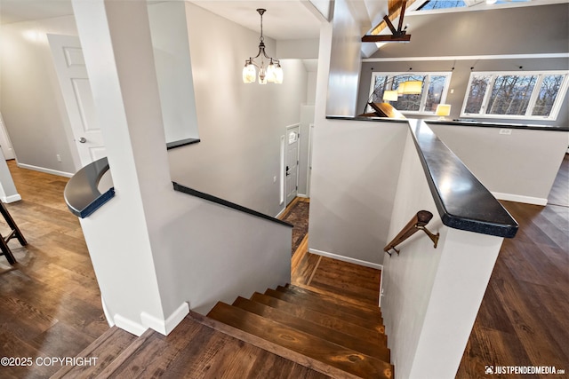 stairs featuring hardwood / wood-style flooring and a chandelier