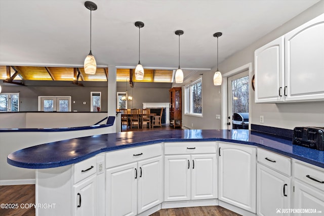 kitchen featuring white cabinetry, pendant lighting, hardwood / wood-style flooring, and kitchen peninsula