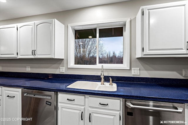 kitchen featuring stainless steel dishwasher, sink, and white cabinetry