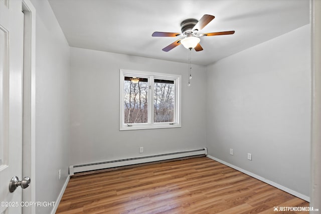 unfurnished room featuring baseboard heating, ceiling fan, and light hardwood / wood-style floors