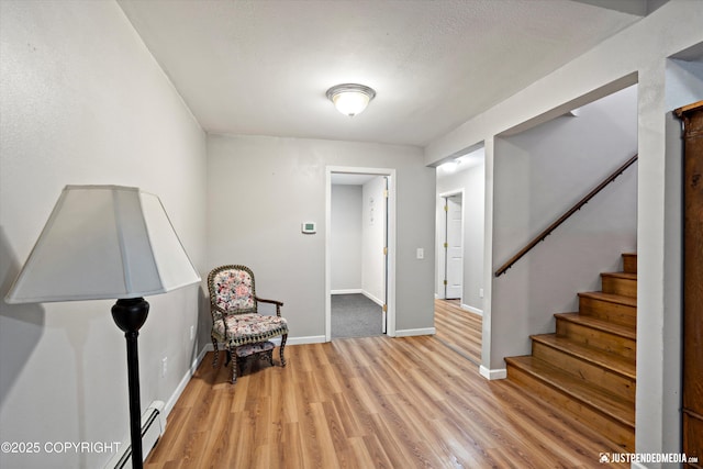 living area with a baseboard radiator and light hardwood / wood-style floors