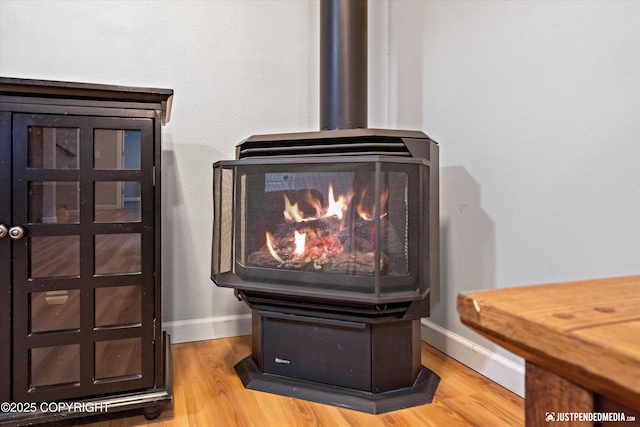 interior details with a wood stove and hardwood / wood-style floors