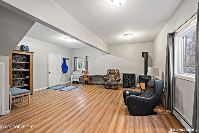 living area with wood-type flooring and a baseboard radiator