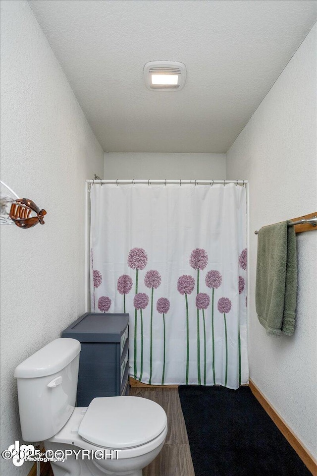 bathroom featuring hardwood / wood-style flooring and toilet