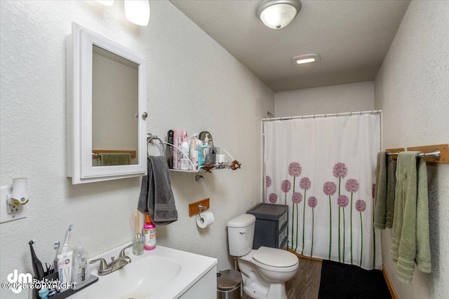 bathroom with vanity, hardwood / wood-style floors, toilet, and walk in shower