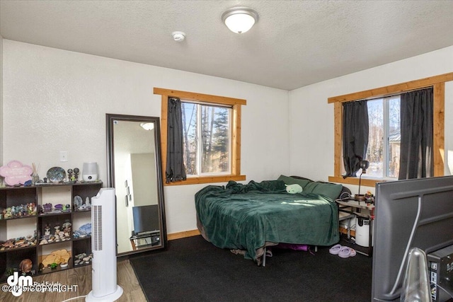 bedroom featuring wood-type flooring and a textured ceiling