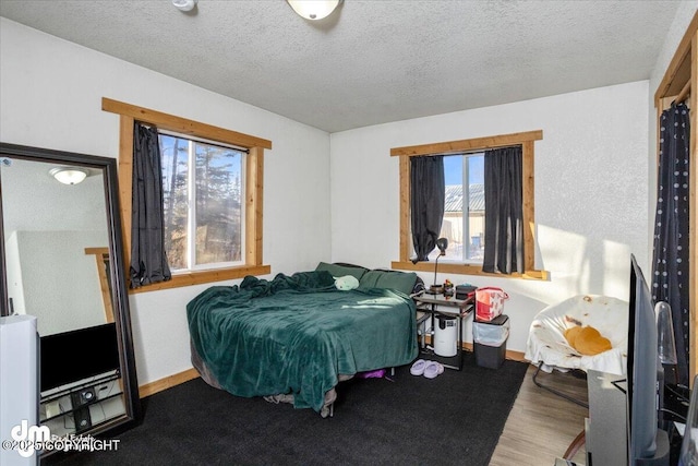 bedroom featuring hardwood / wood-style flooring and a textured ceiling