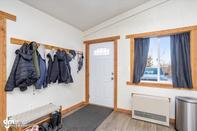 foyer featuring hardwood / wood-style flooring, vaulted ceiling, and heating unit