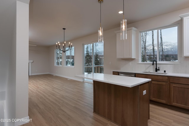 kitchen with a center island, a mountain view, sink, and white cabinets