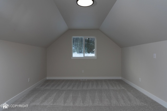 bonus room with vaulted ceiling and carpet flooring