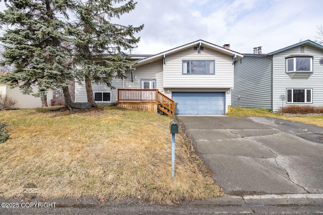 raised ranch with an attached garage, driveway, and a front yard