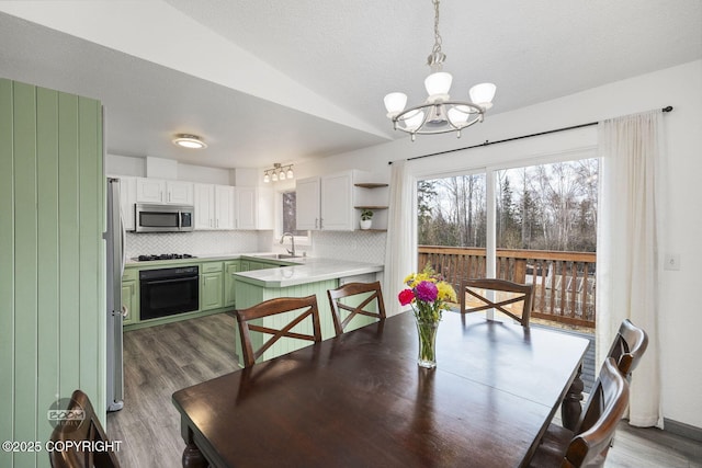 dining area featuring lofted ceiling, wood finished floors, a textured ceiling, and a chandelier