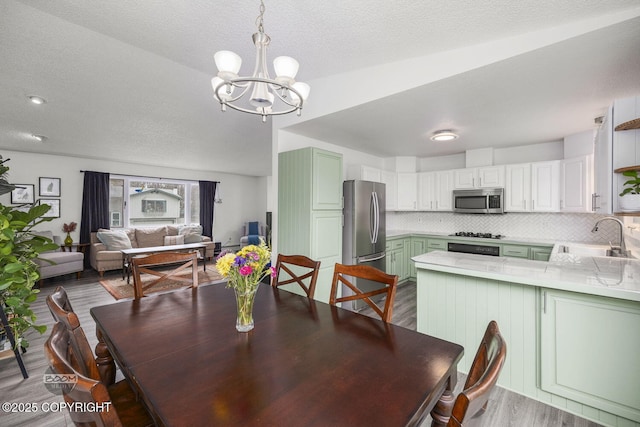 dining space featuring a chandelier, wood finished floors, and a textured ceiling