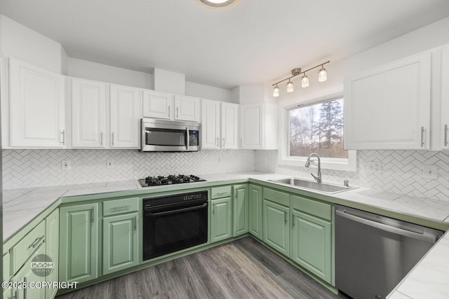 kitchen featuring a sink, tasteful backsplash, white cabinetry, light countertops, and black appliances