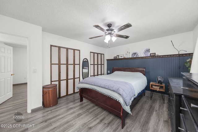 bedroom featuring wood finished floors, a textured ceiling, and ceiling fan