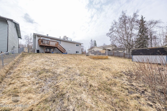 view of yard featuring an outdoor structure, fence, stairway, and a deck