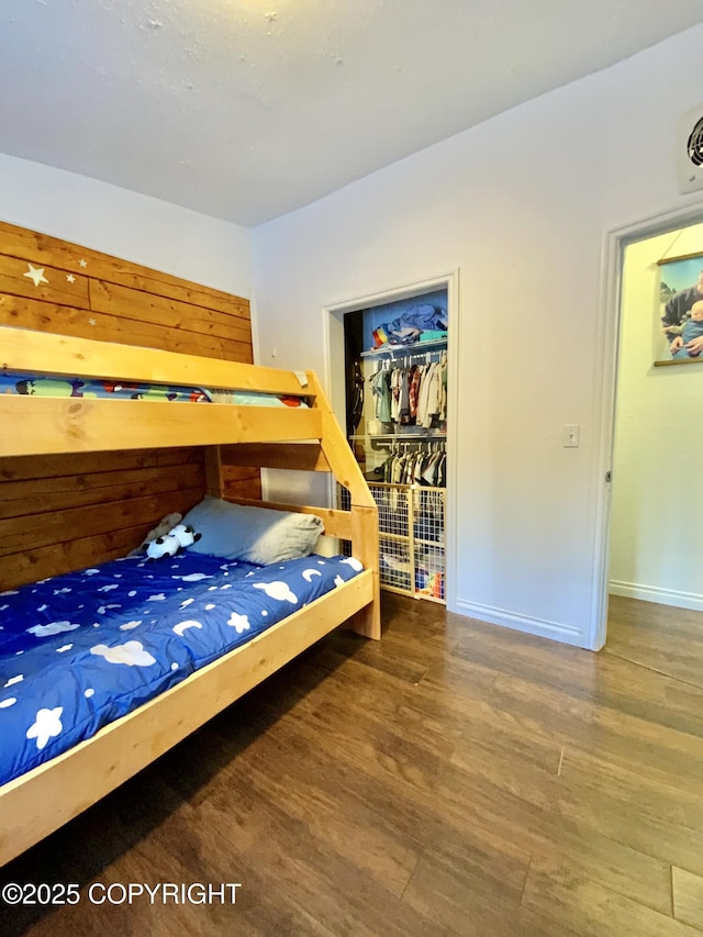 bedroom featuring wood-type flooring, a spacious closet, and a closet