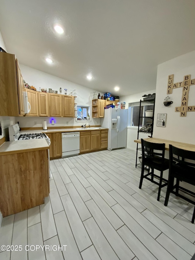 kitchen featuring lofted ceiling, sink, and white appliances