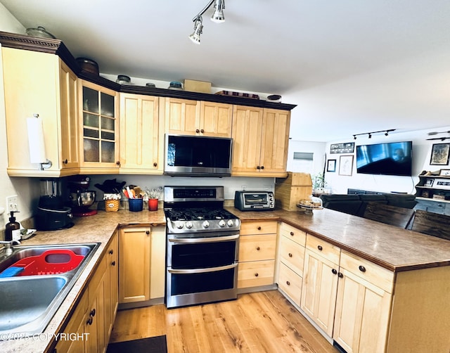 kitchen featuring light brown cabinetry, sink, light hardwood / wood-style flooring, and appliances with stainless steel finishes