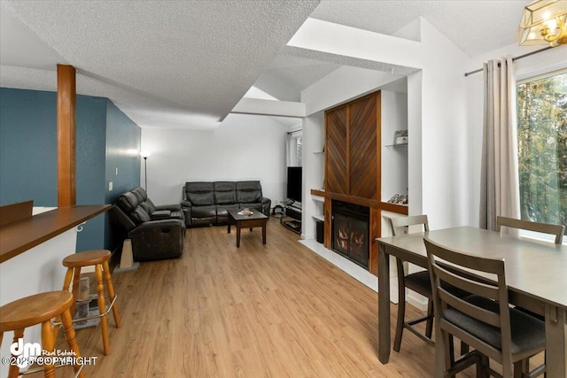 living room with a textured ceiling and light wood-type flooring