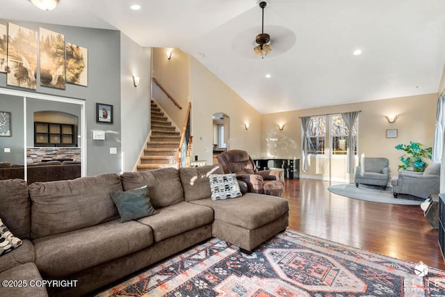 living room with hardwood / wood-style flooring, ceiling fan, and high vaulted ceiling