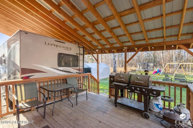 deck with a playground, a trampoline, and a shed