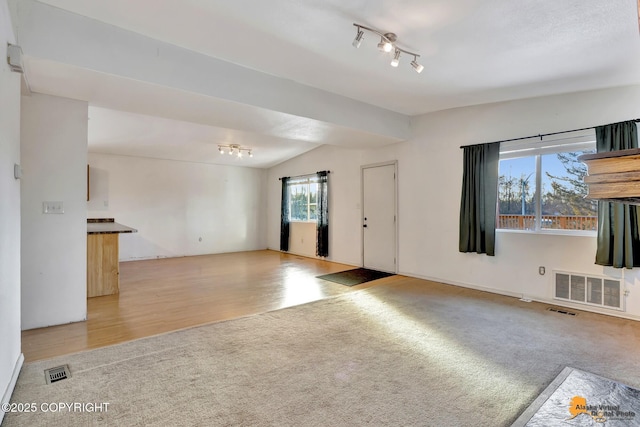 unfurnished living room with visible vents, vaulted ceiling, and carpet flooring