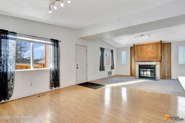 unfurnished living room featuring light wood-type flooring, a fireplace, and visible vents