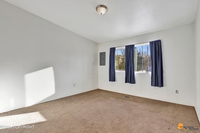 empty room with visible vents, carpet, and electric panel