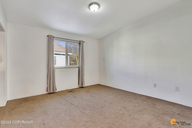 carpeted spare room featuring visible vents