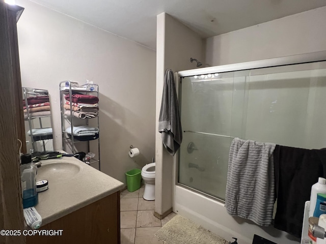 full bathroom with tile patterned flooring, enclosed tub / shower combo, vanity, and toilet