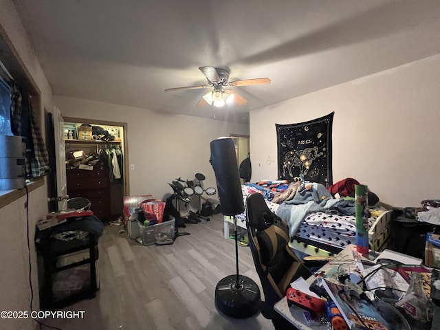 bedroom with hardwood / wood-style flooring, ceiling fan, and a closet