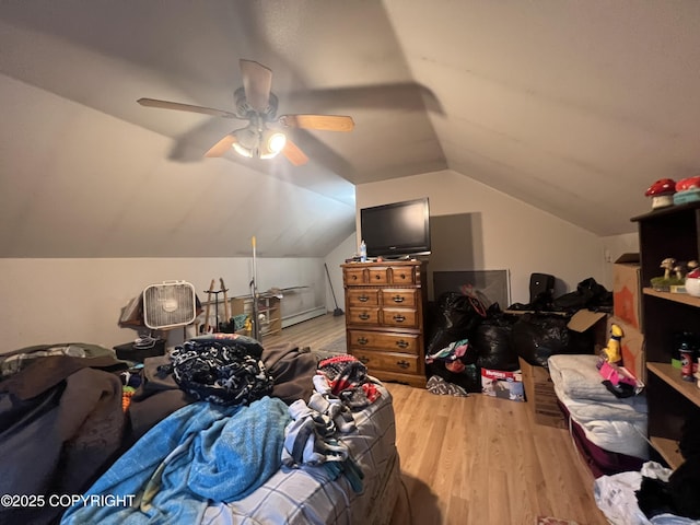 bedroom featuring ceiling fan, wood-type flooring, a baseboard radiator, and vaulted ceiling