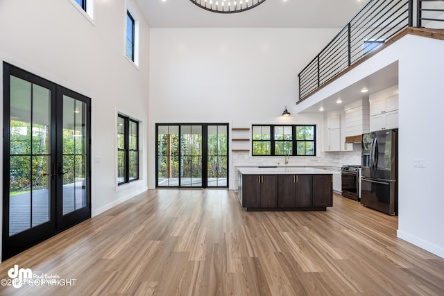 kitchen featuring white cabinetry, sink, a center island, stainless steel appliances, and dark brown cabinets