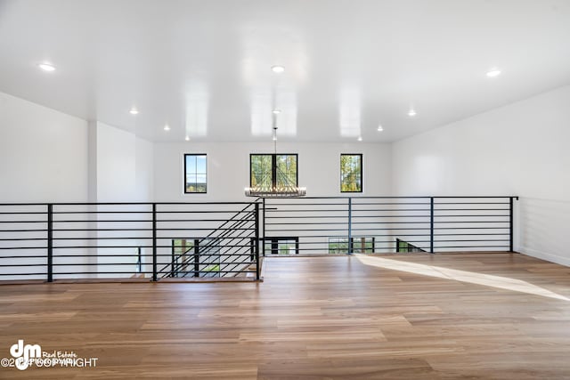 interior space with a wealth of natural light, wood-type flooring, and a chandelier